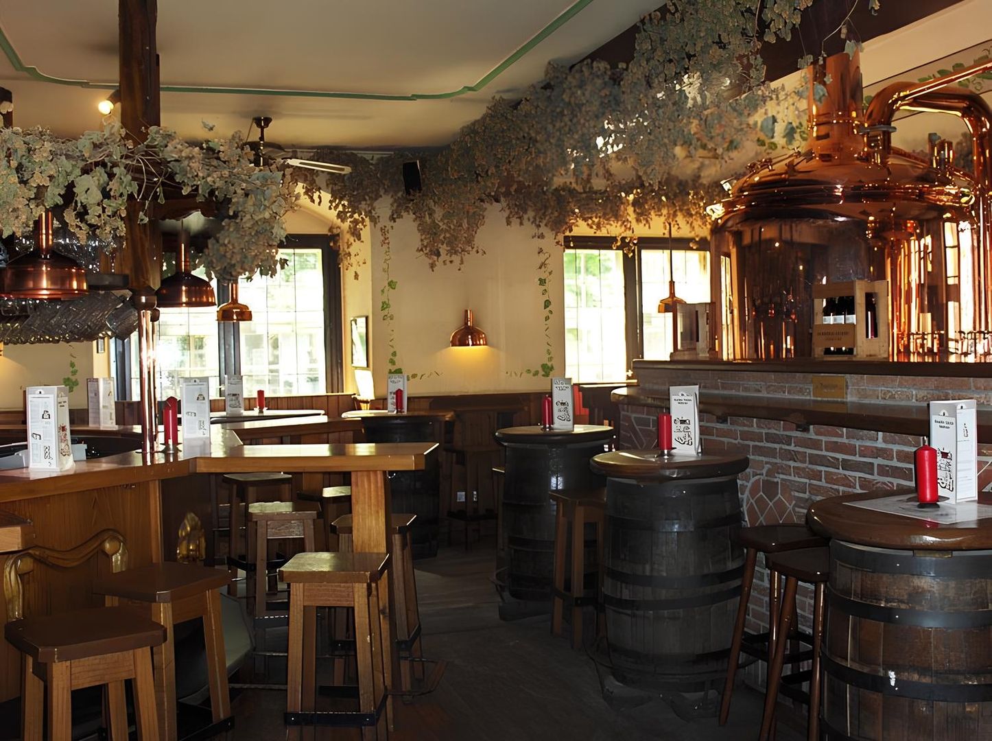 Brewery with wooden chairs and a large copper pot in the background, cosy atmosphere and rustic design